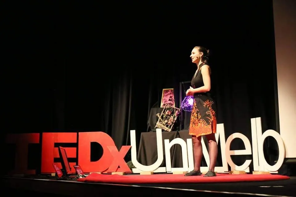 Daria Vodopianova speaking on a TEDx stage.